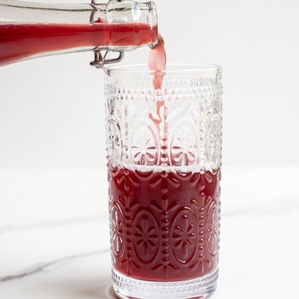 someone pouring a glass of fermented water kefir.
