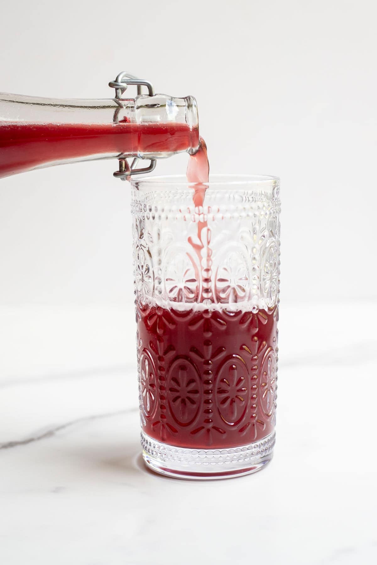 someone pouring a glass of fermented water kefir. 