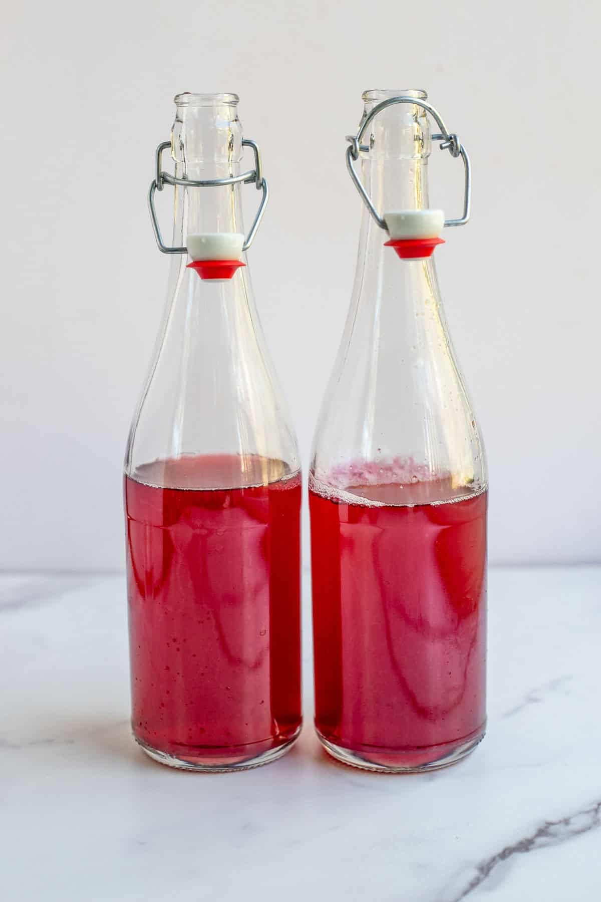 Water kefir and juice in a glass flip top bottle.