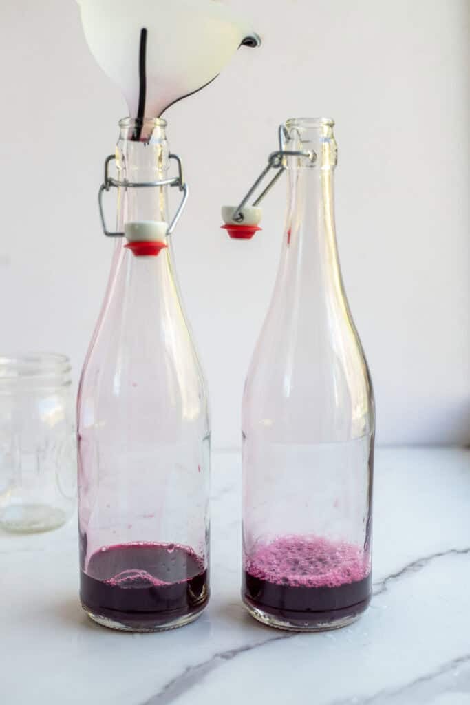Fruit juice added to a glass flip top bottle. 