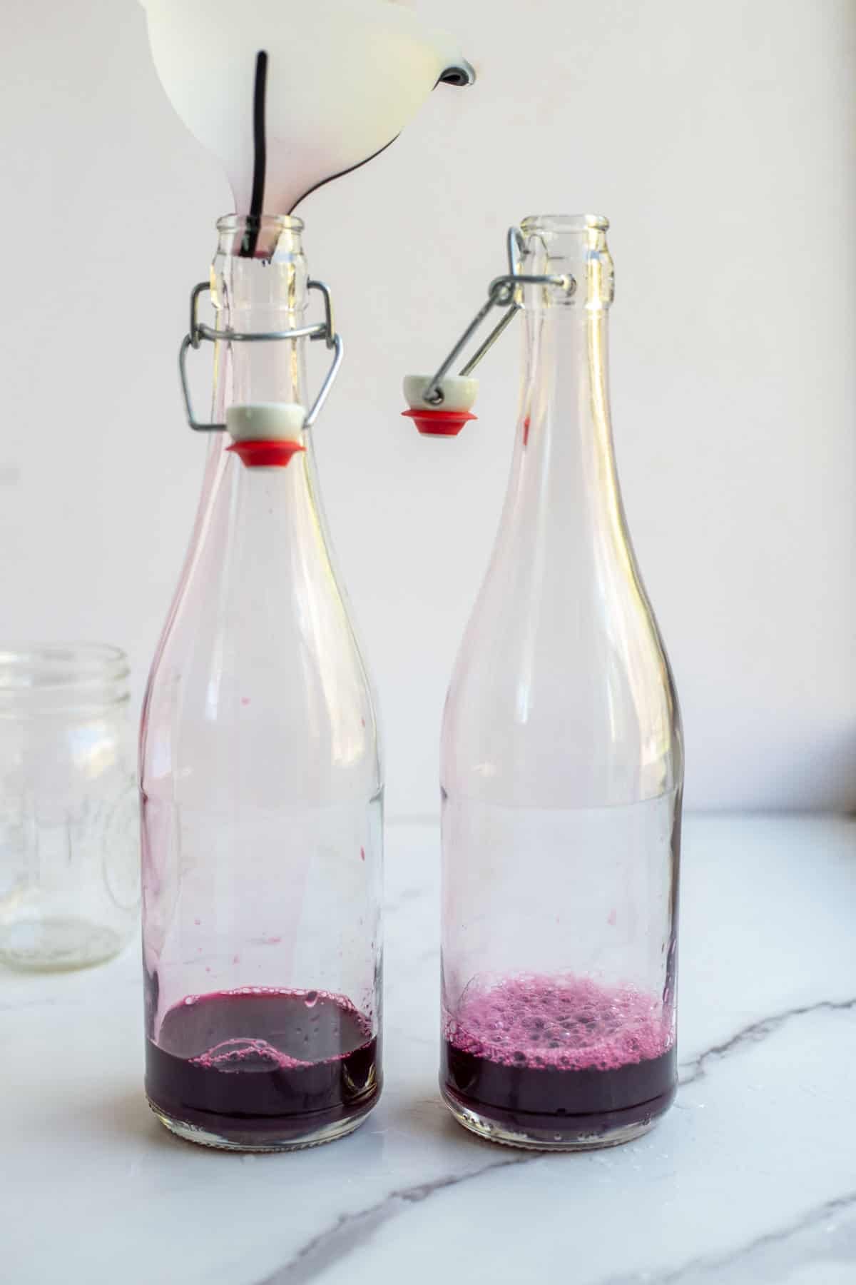 Fruit juice added to a glass flip top bottle.