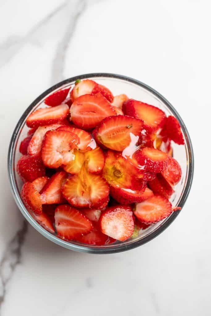 Sliced strawberries in a bowl.