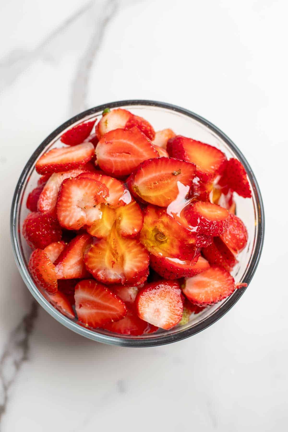 Sliced strawberries in a bowl.