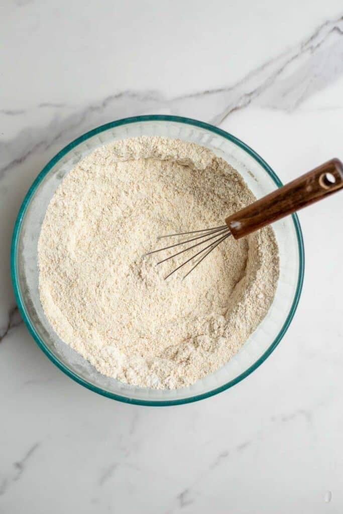 Dry ingredients in a bowl with a whisk.