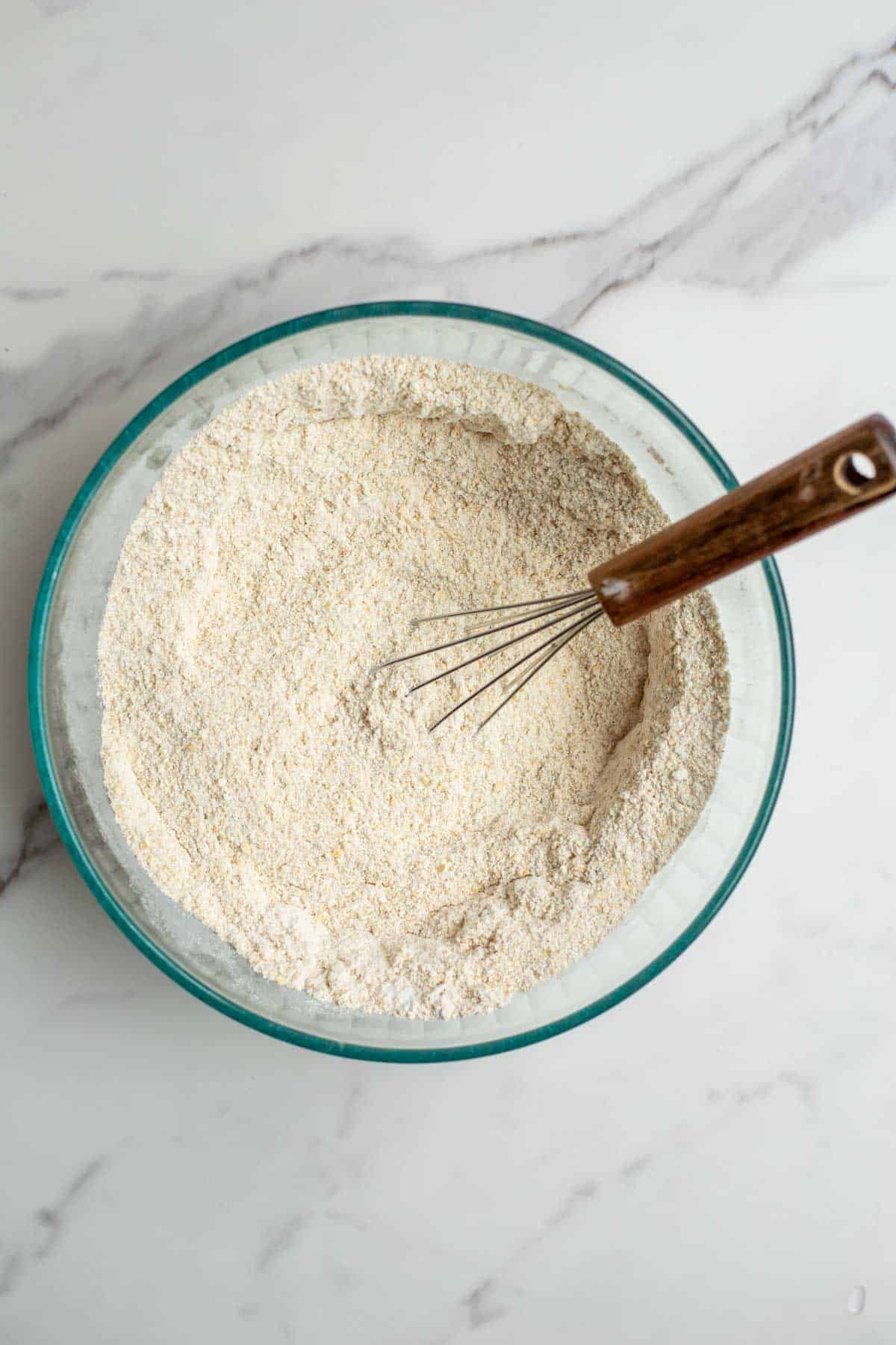 Dry ingredients in a bowl with a whisk.