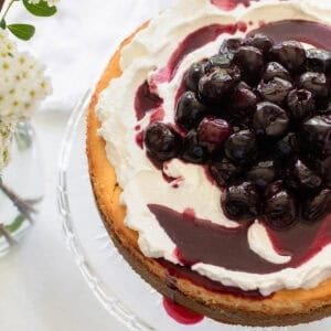 A cheesecake on a cake stand.