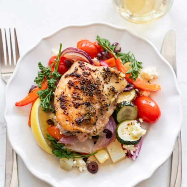 A plate with chicken and veggies on it.