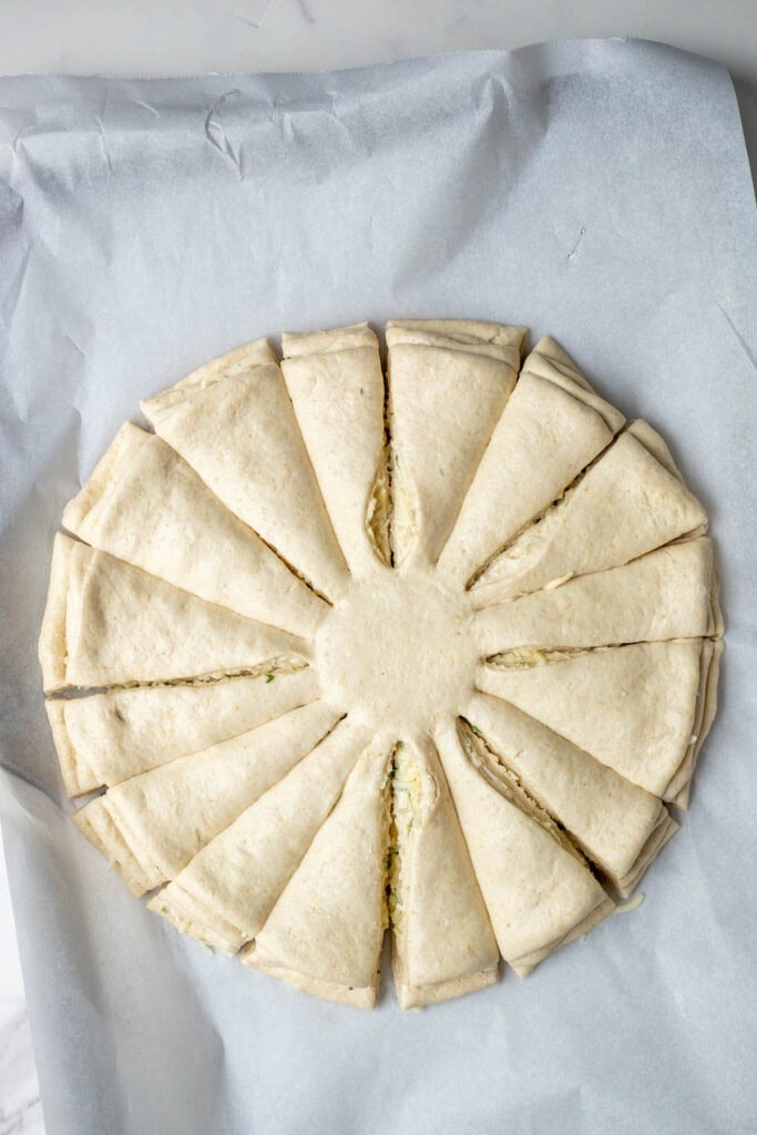 Layers of circular dough cut into 16 equal pieces leaving the centers attached.