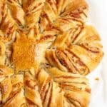 a freshly baked sourdough cheese star on white parchment paper.