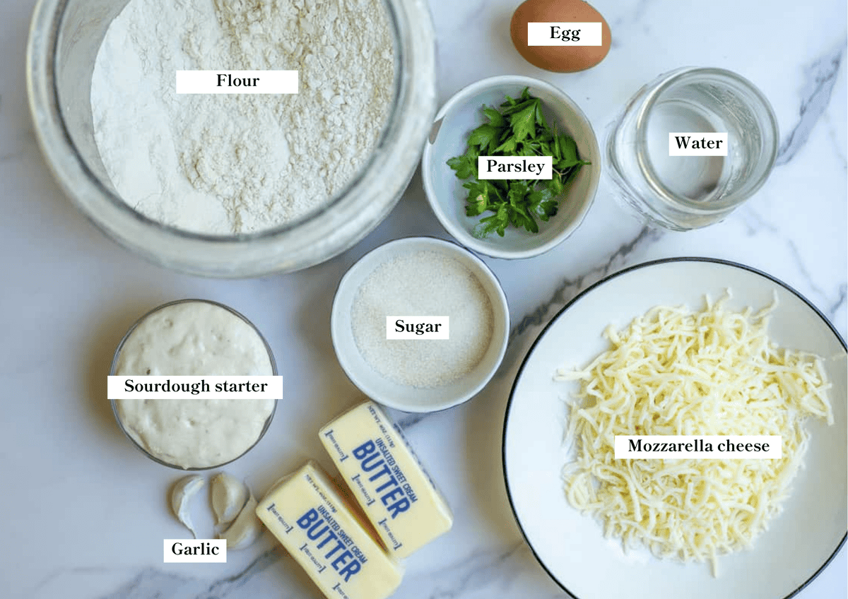 Bowls ingredients on a marble countertop to make a sourdough cheese star.