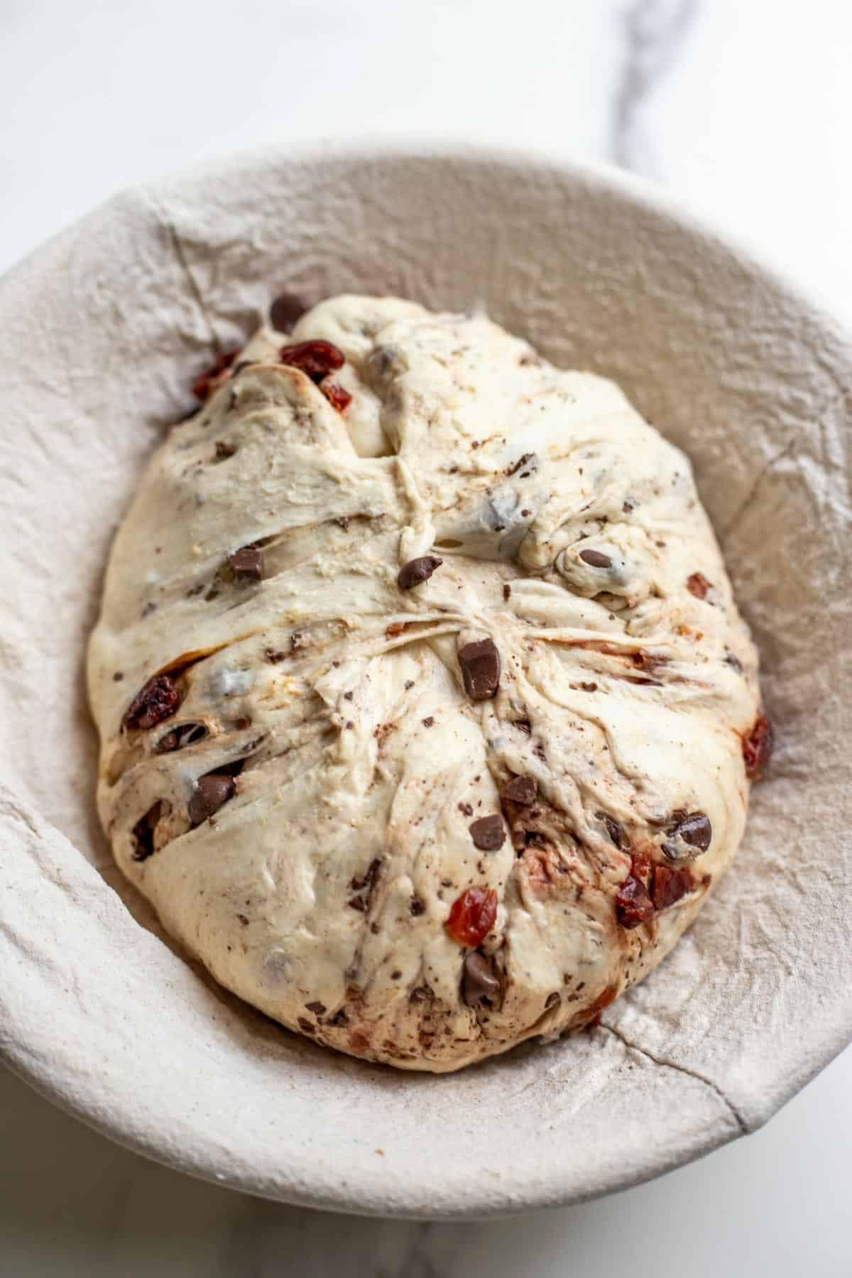 A ball of sourdough bread in a banneton basket.
