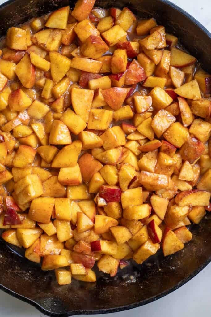 Cooked peaches in a cast iron skillet.