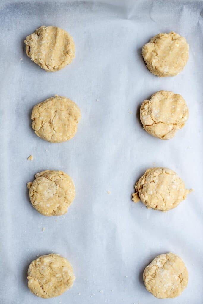 Sourdough sweet biscuit dough scooped out onto a parchment lined baking sheet.