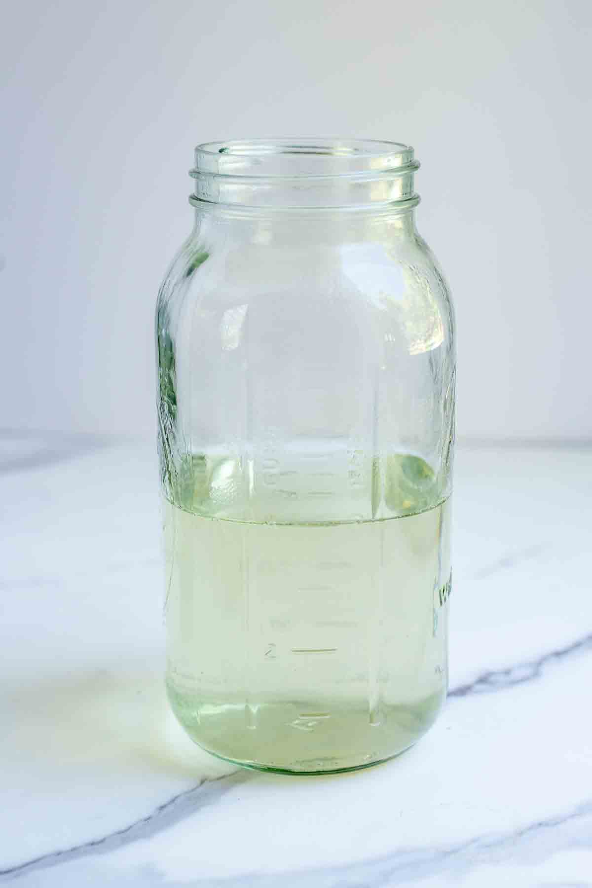 Water and melted sugar in a half gallon mason jar.