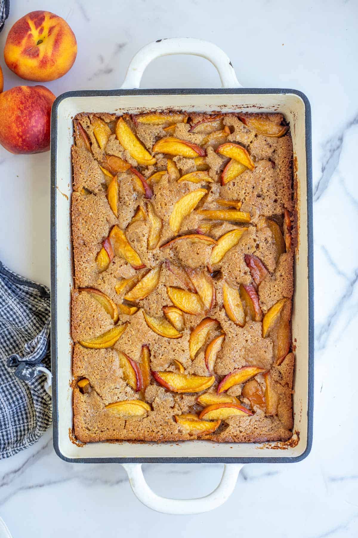 Whole wheat peach cobbler cooked in a cast iron 9" x 13" pan.