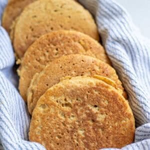 whole wheat crumpets in a tea towel lined basket.