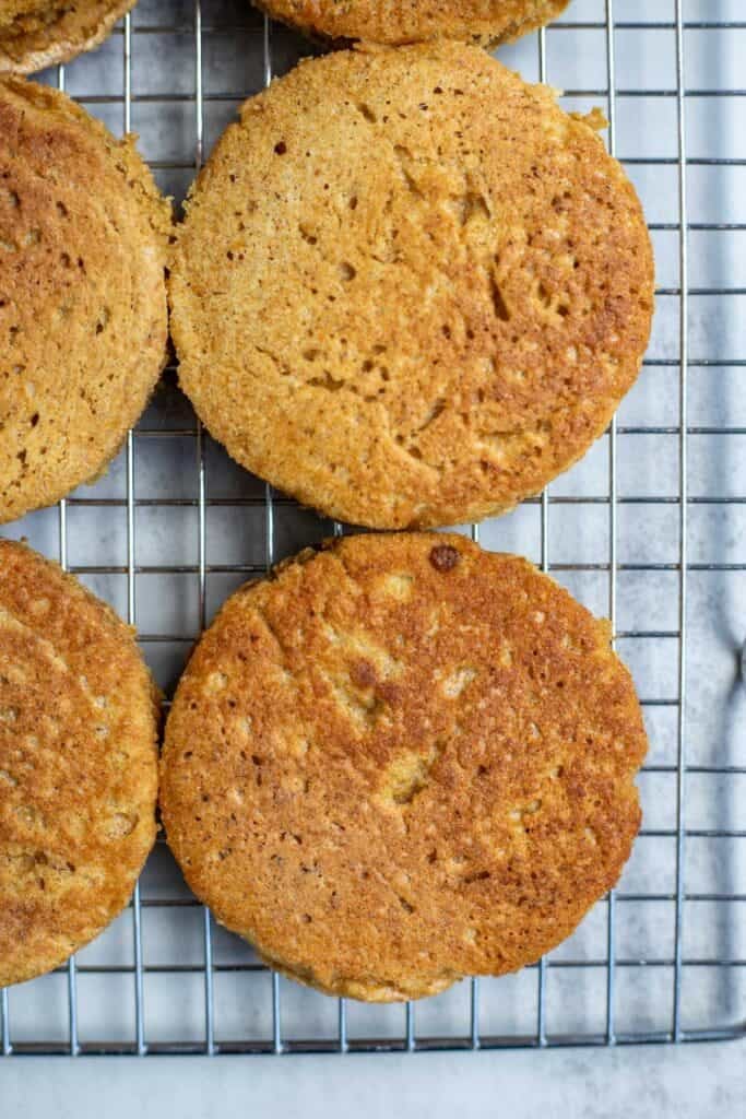 Four whole wheat crumpets cooling on a wire rack.