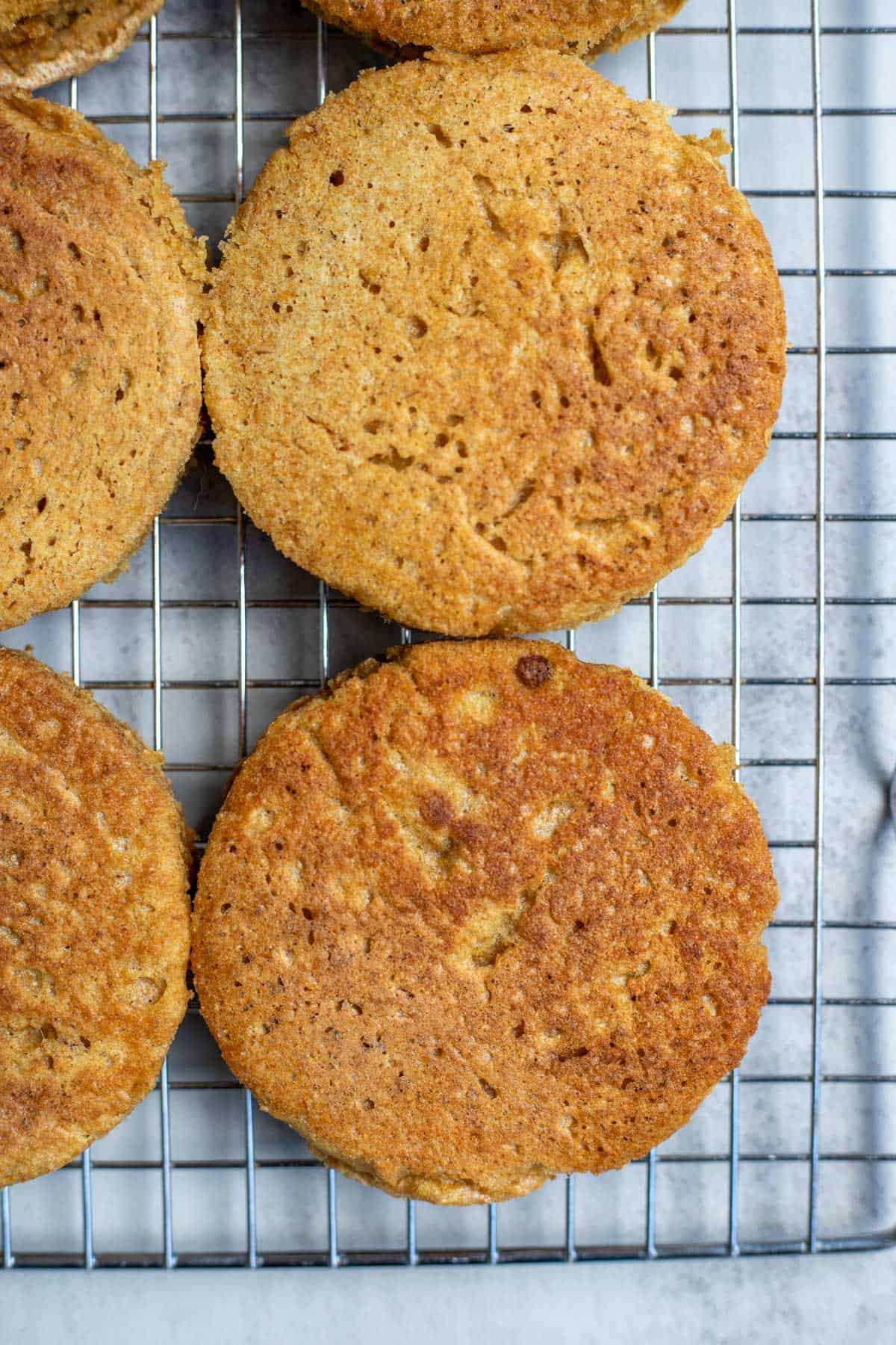 Four whole wheat crumpets cooling on a wire rack.