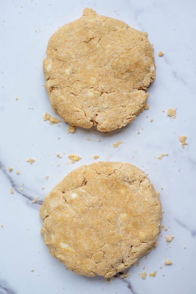 Pie crust dough divided into two equal pieces.