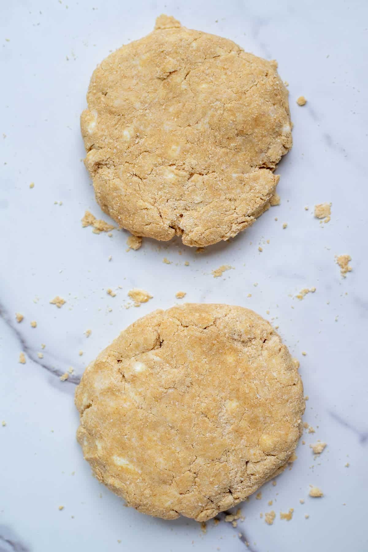 Pie crust dough divided into two equal pieces.