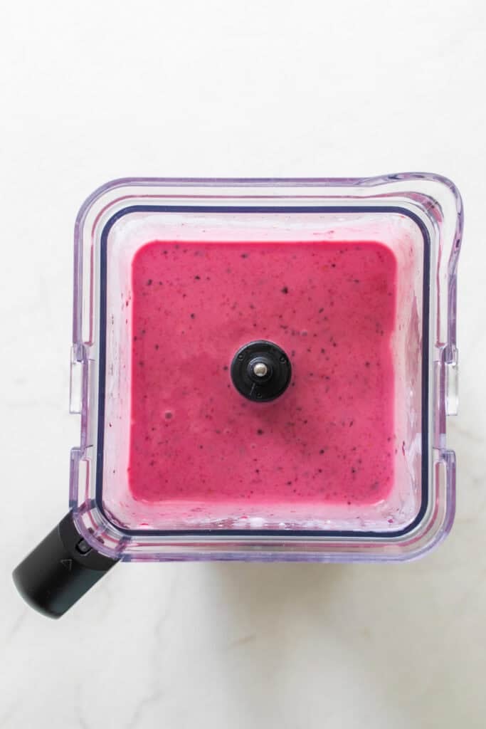 A blender with a smooth mixture of smoothie.
