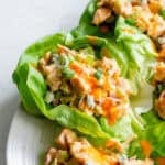 Buffalo chicken salad in lettuce cups on a plate.