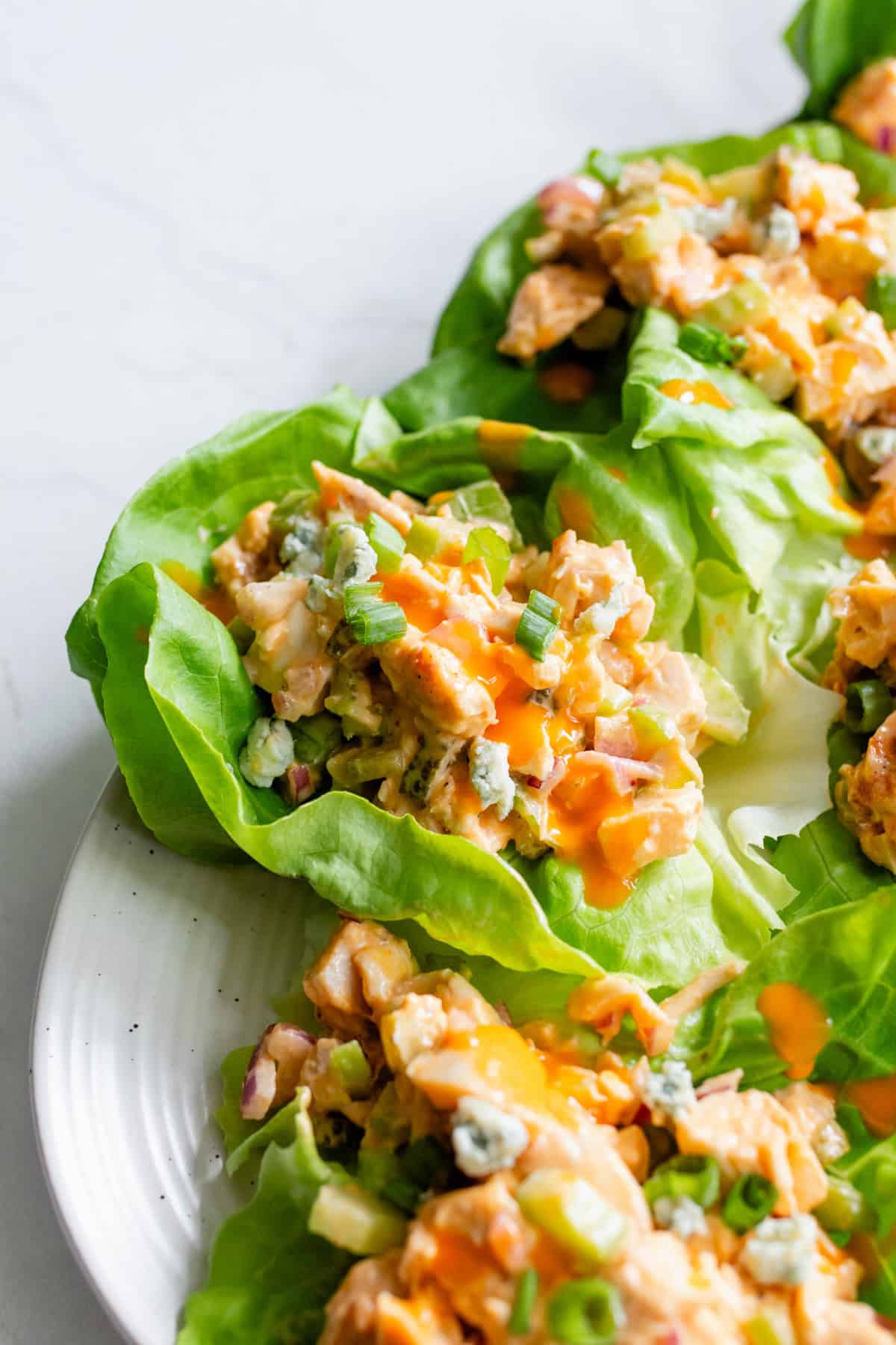 Buffalo chicken salad in lettuce cups on a plate.