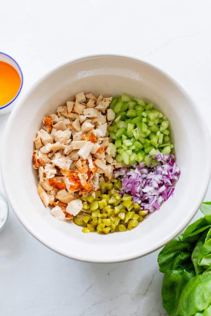 Ingredients for buffalo chicken salad separated out in a bowl.