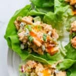 Buffalo chicken salad in lettuce cups on a white platter.