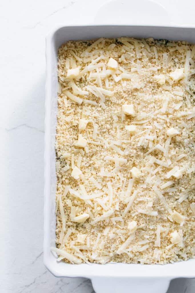 Cheese covering zucchini and cream mixture in a casserole dish.