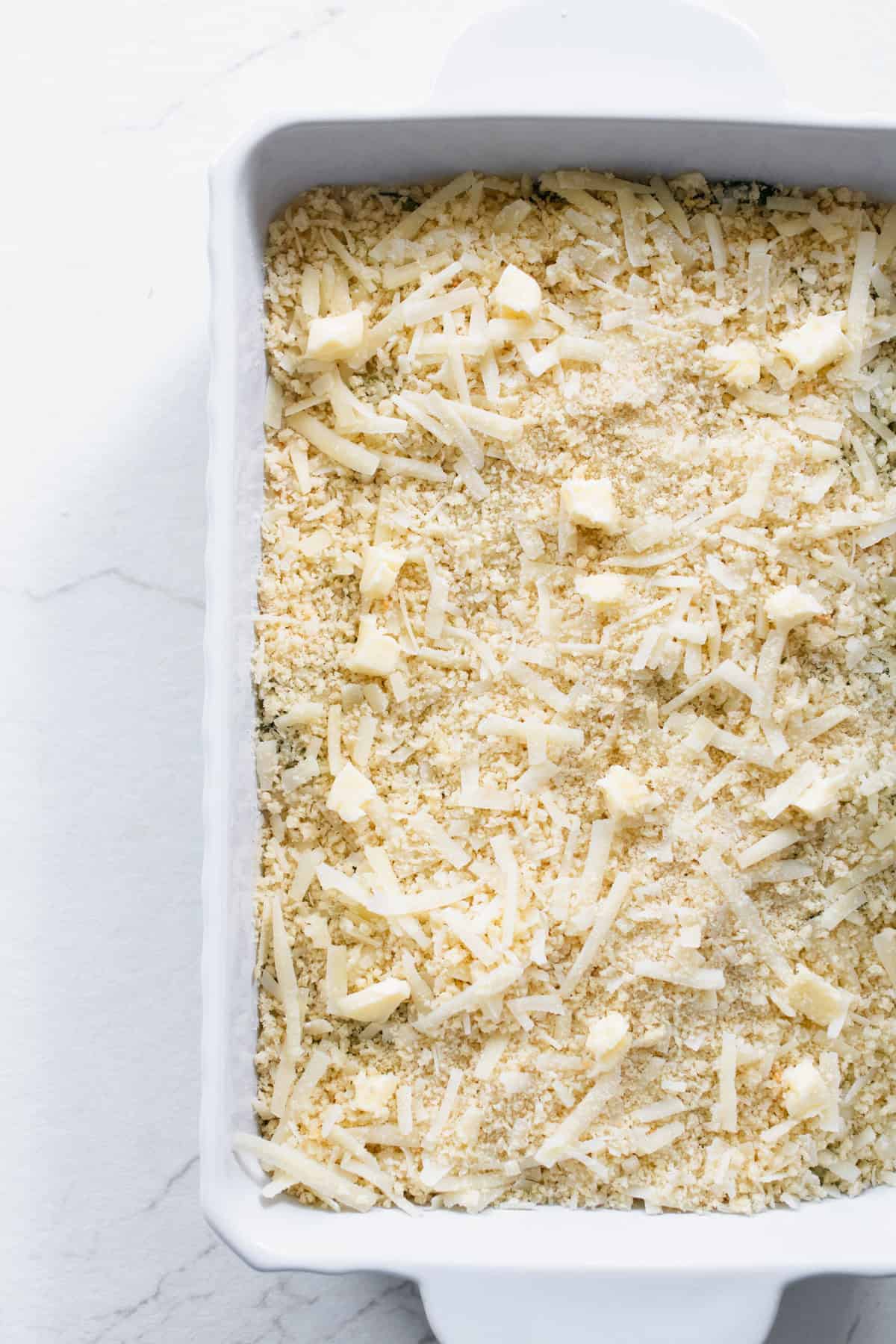 Cheese covering zucchini and cream mixture in a casserole dish.