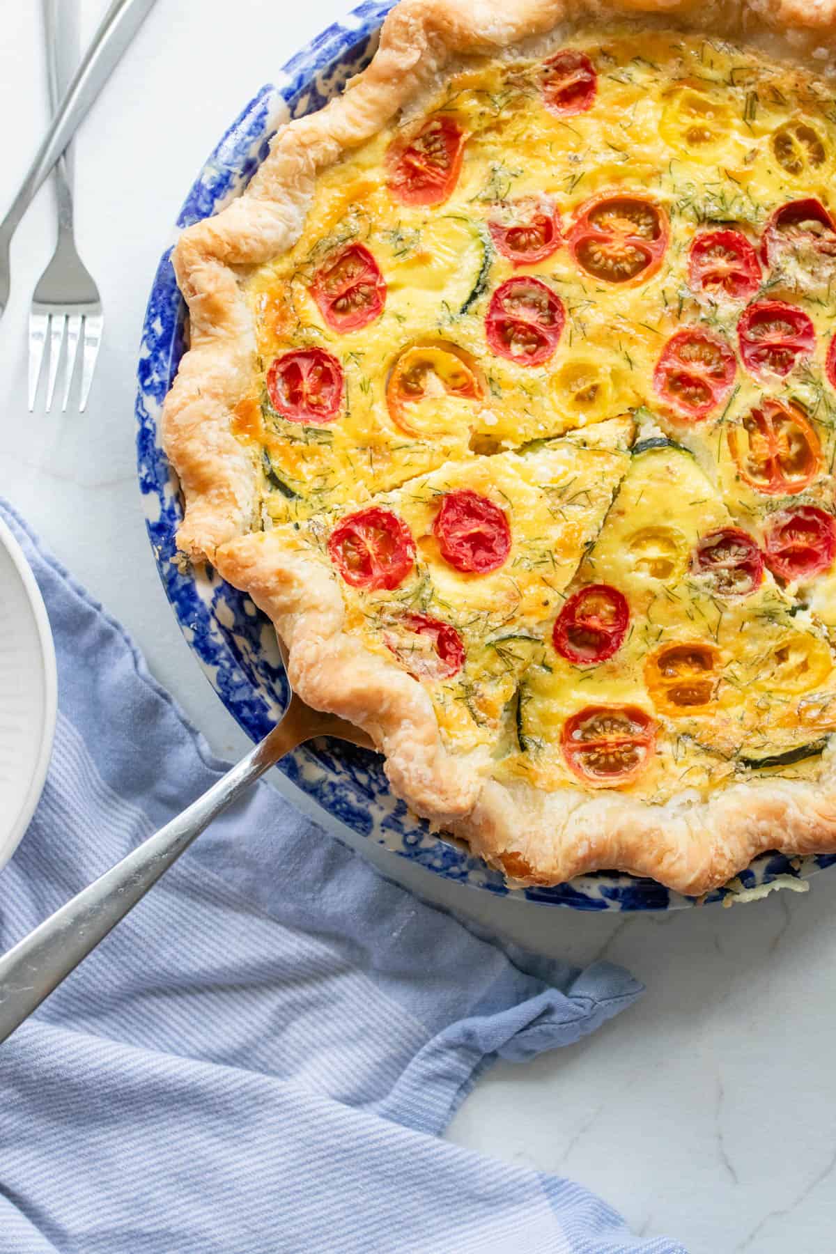 A pie plate with a zucchini quiche.