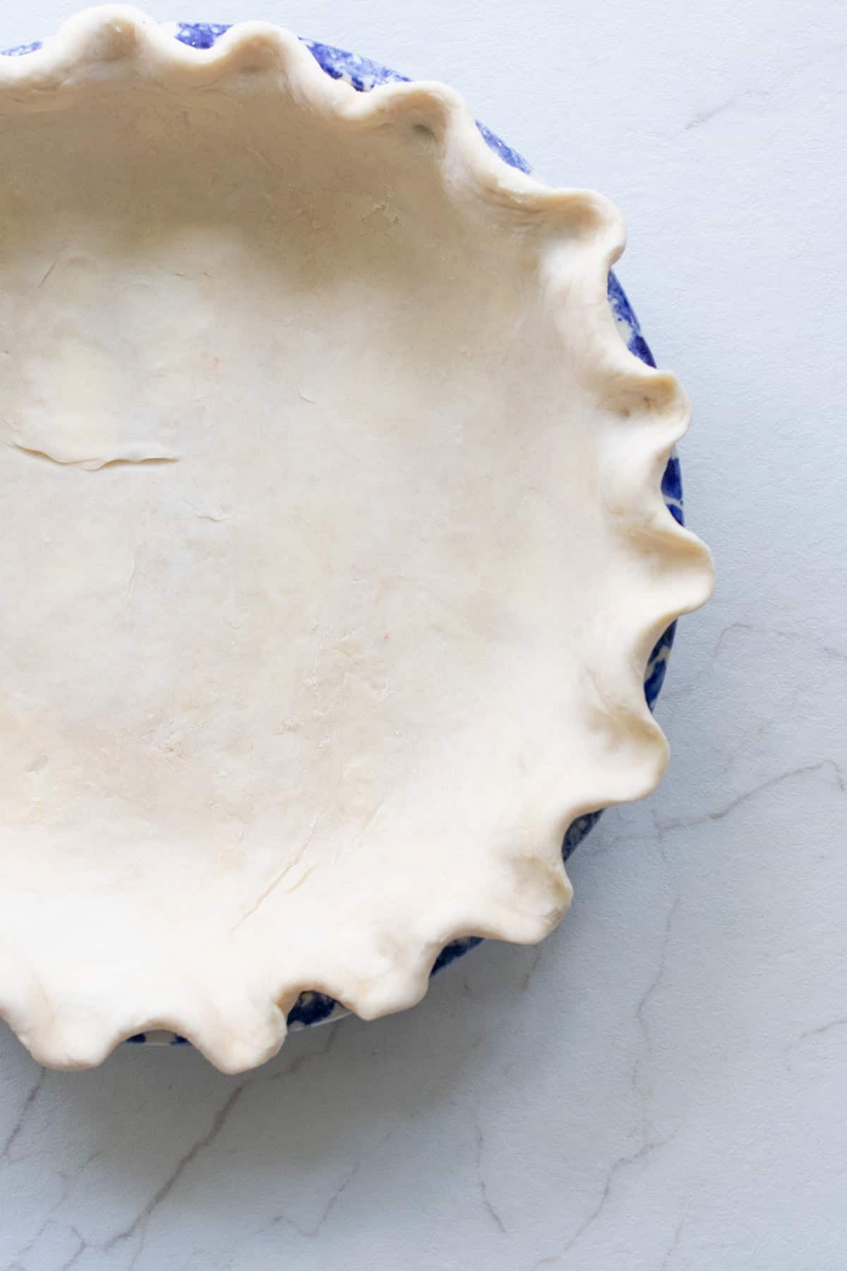 A pie plate with a pie crust perfectly inside it.