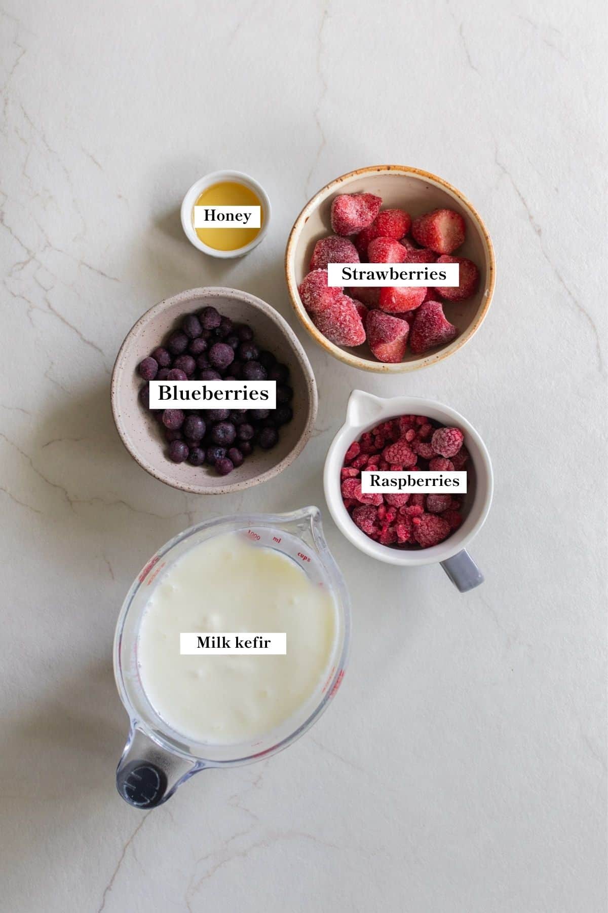Ingredients in bowls for a kefir smoothie on a counter top.