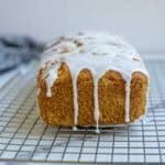 powdered sugar glaze poured over a peach bread.