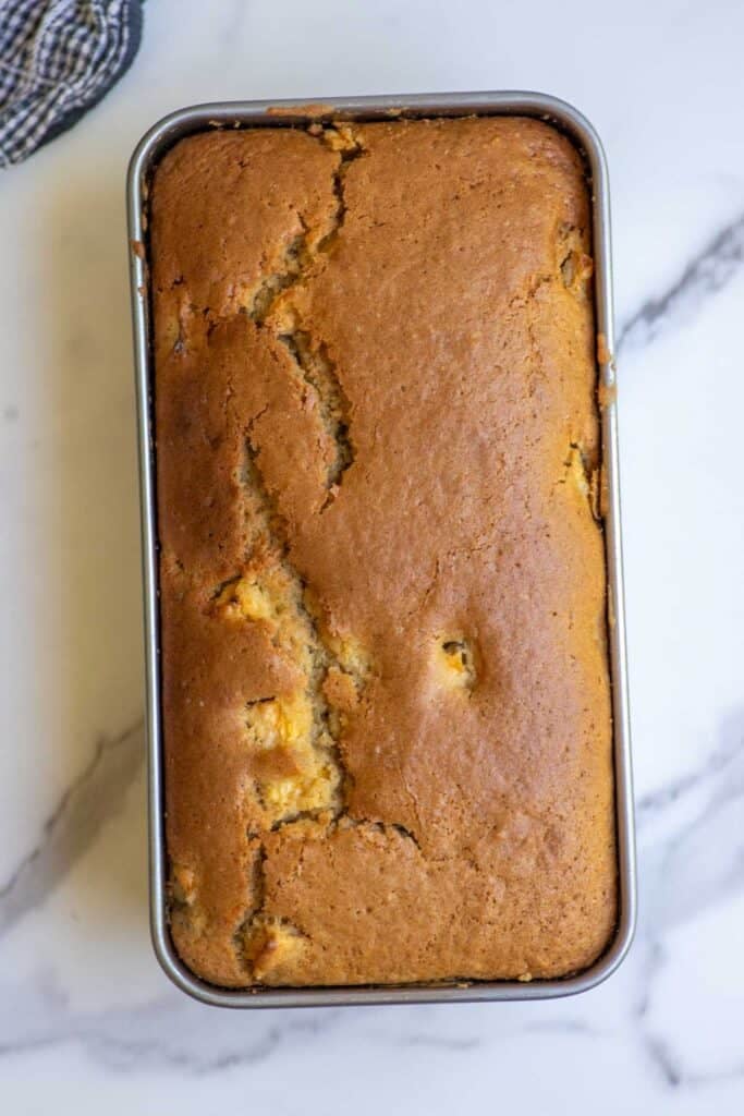 Sourdough peach bread baked fresh in a metal loaf pan.