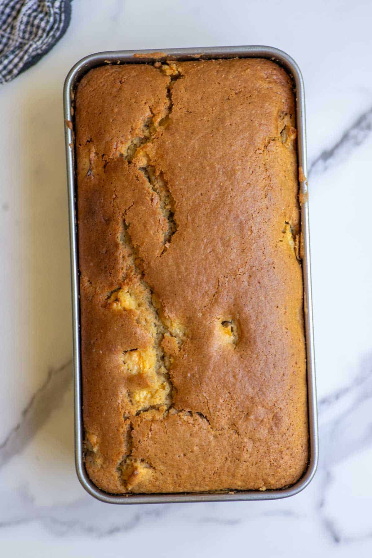 Sourdough peach bread baked fresh in a metal loaf pan.