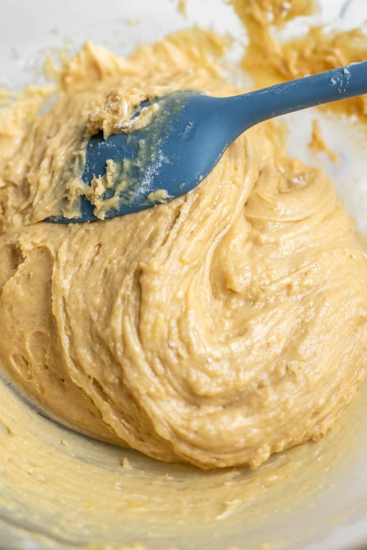 Wet ingredients mixed together in a bowl with dry ingredients for a peach bread.