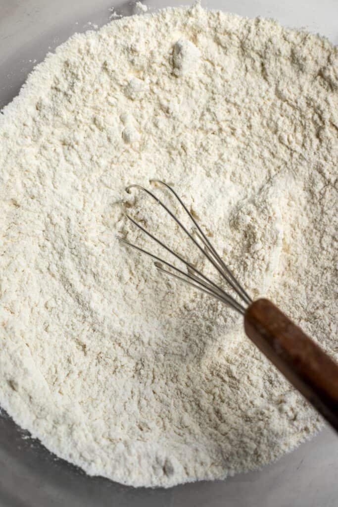 Flour, baking powder, baking soda, and salt mixed together with a whisk.