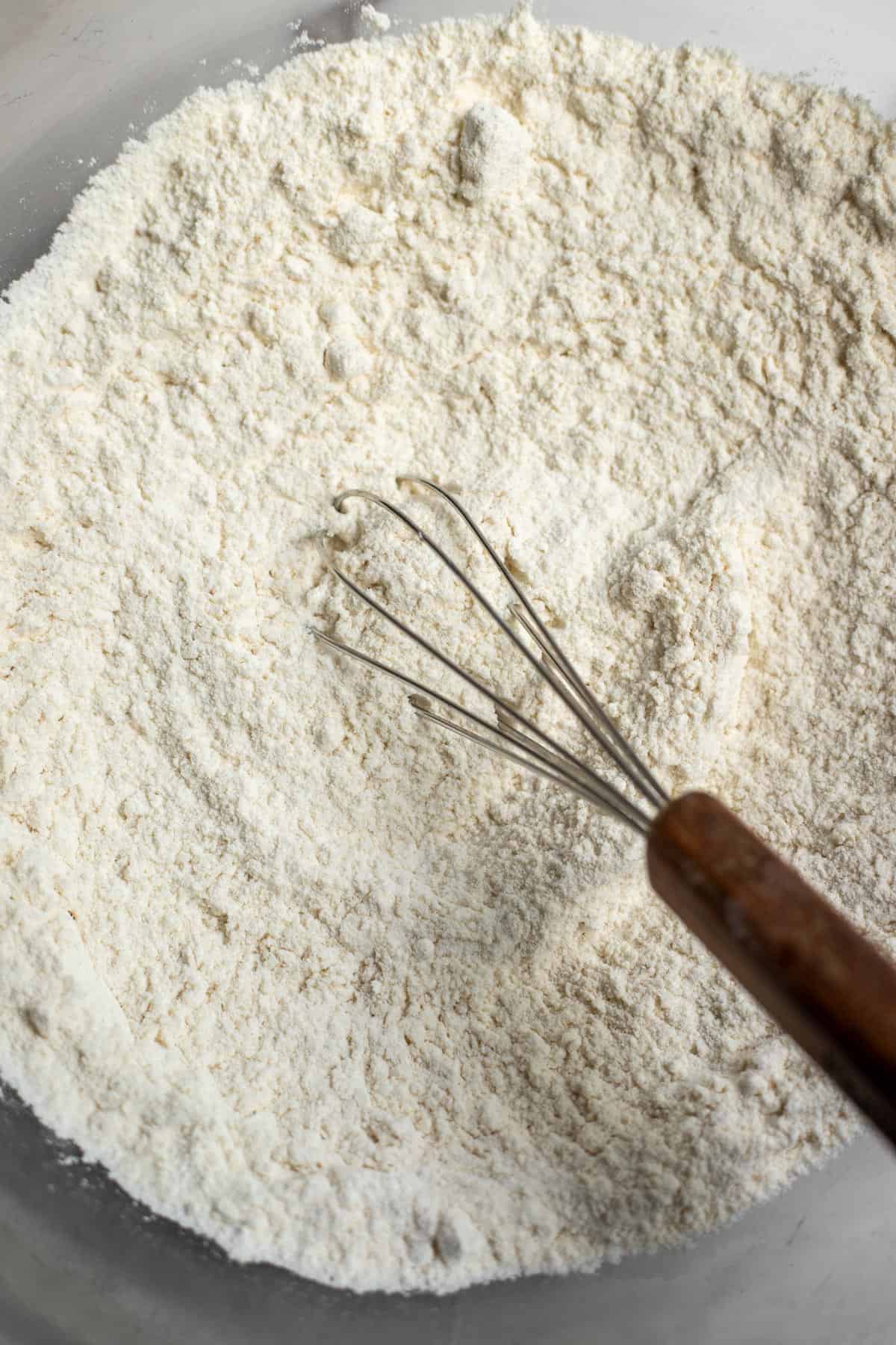 Flour, baking powder, baking soda, and salt mixed together with a whisk.