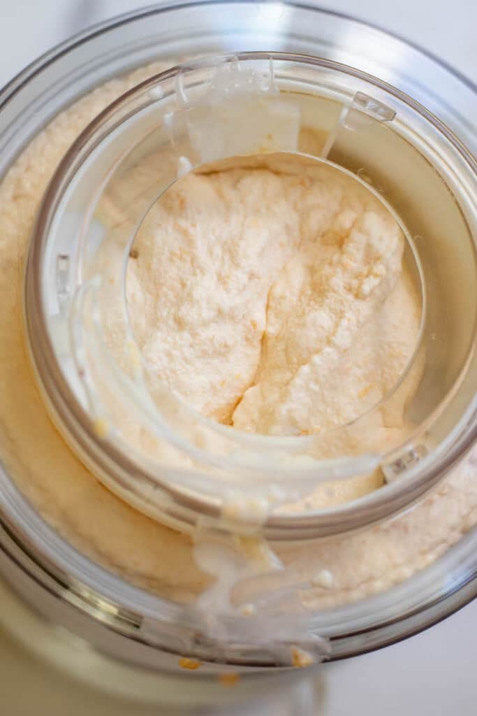 Peach ice cream ingredients added into an ice cream maker.