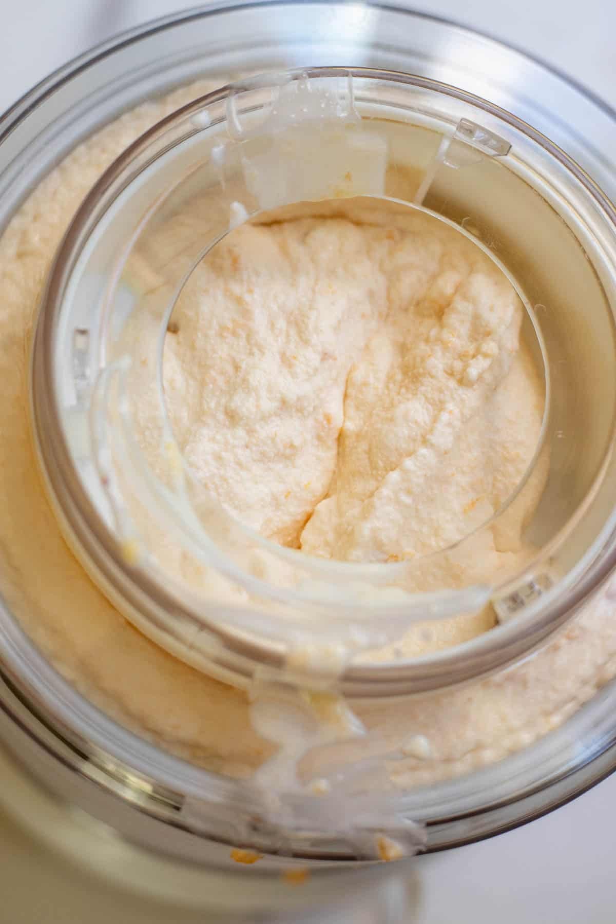 Peach ice cream ingredients added into an ice cream maker.