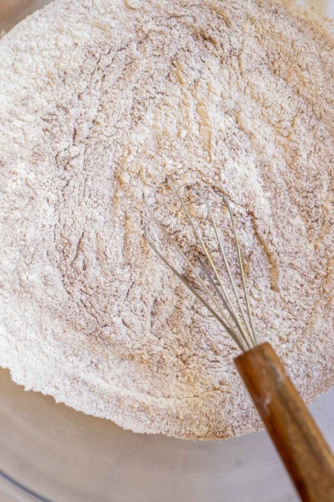 Dry ingredients in a bowl with a whisk.