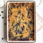 A golden brown blueberry cobbler in a 9 by 13 inch baking dish.