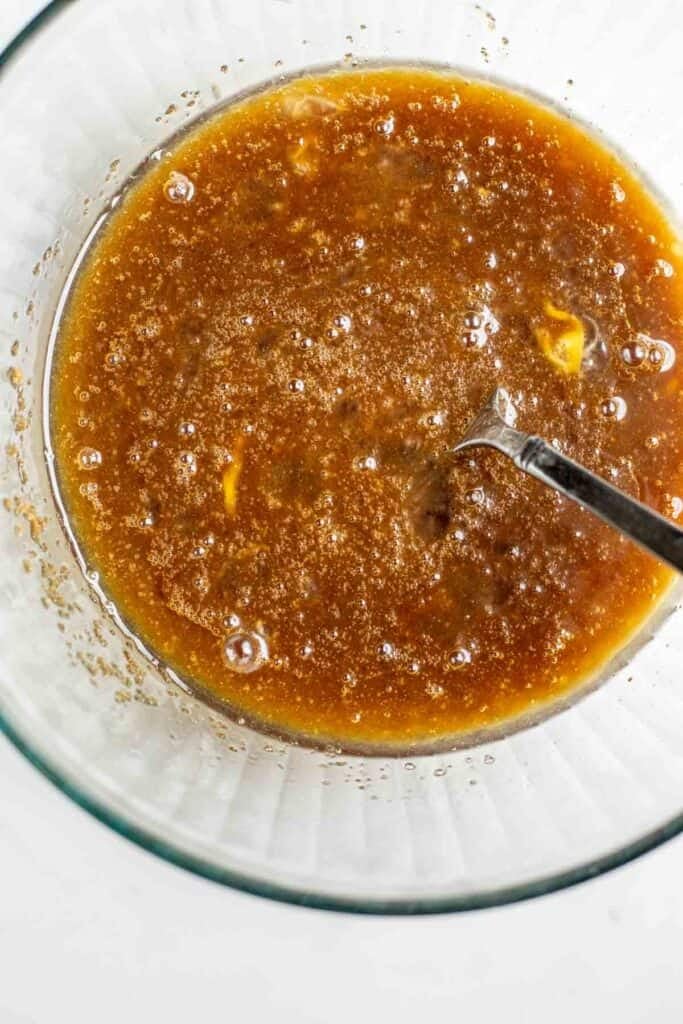 Wet ingredients mixed together in a bowl with a fork.