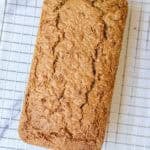 A baked loaf of zucchini bread on a wire rack.