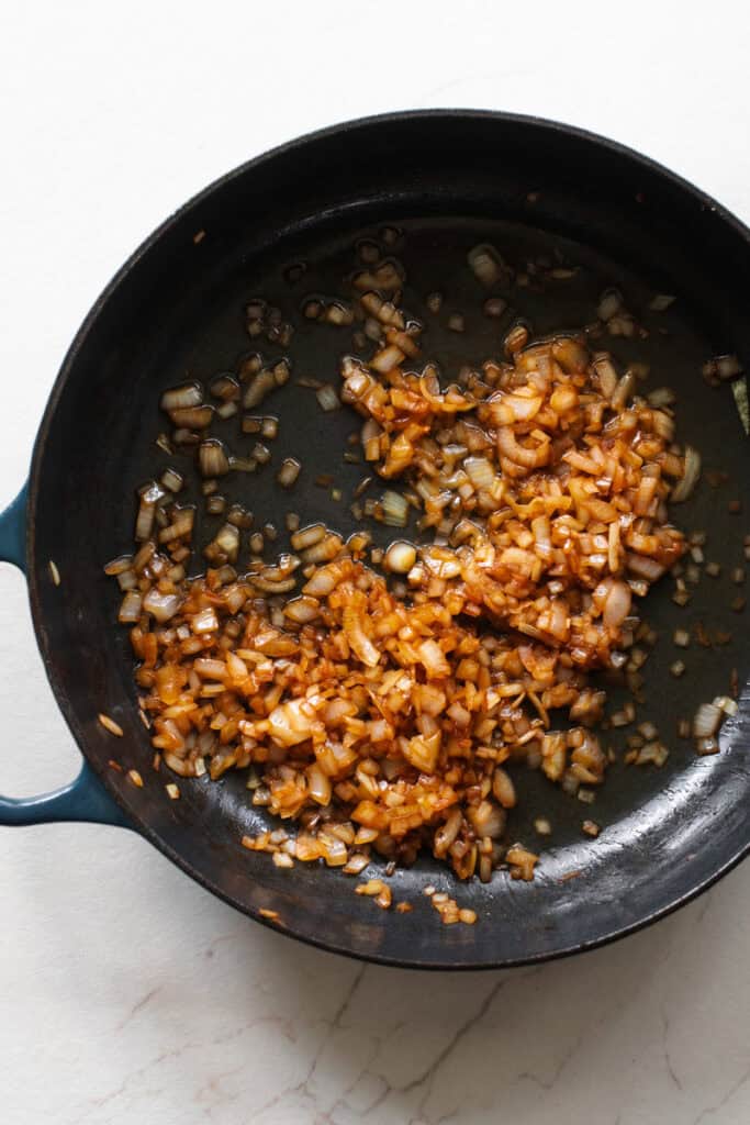 Onions cooked in butter and white wine in a cast iron skillet.