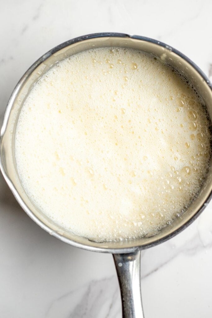 A saucepan with an ice cream mixture inside on a counter top.