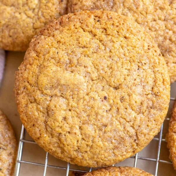 Sourdough pumpkin cookies stacked on a wire rack.
