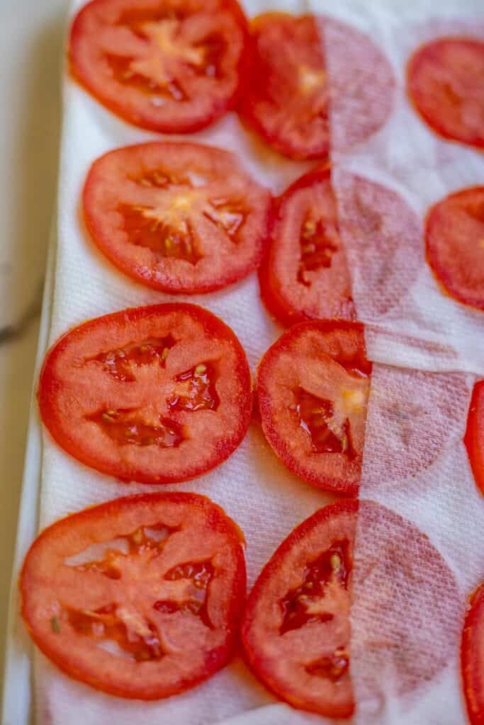 Sliced tomatoes laid out on a paper towel.